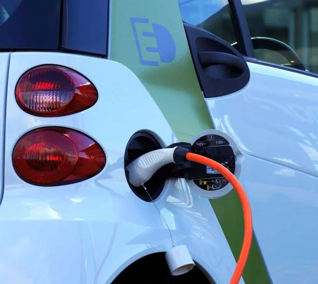 An electric car charging up, with "240V~" and "110V~" printed on the label.