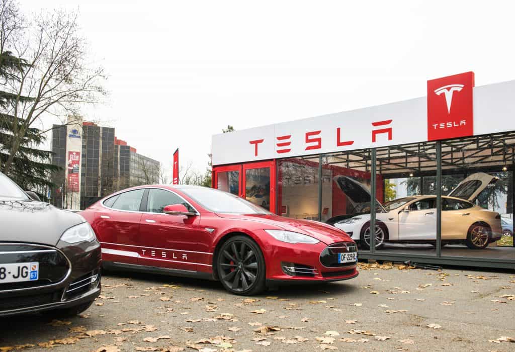 PARIS, FRANCE - NOVEMBER 29: Tesla Model S showroom and two luxury tesla cars outside and one inside. Tesla is an American company that designs, manufactures,