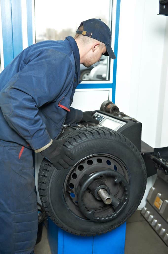 A mechanic changing and balancing a tire