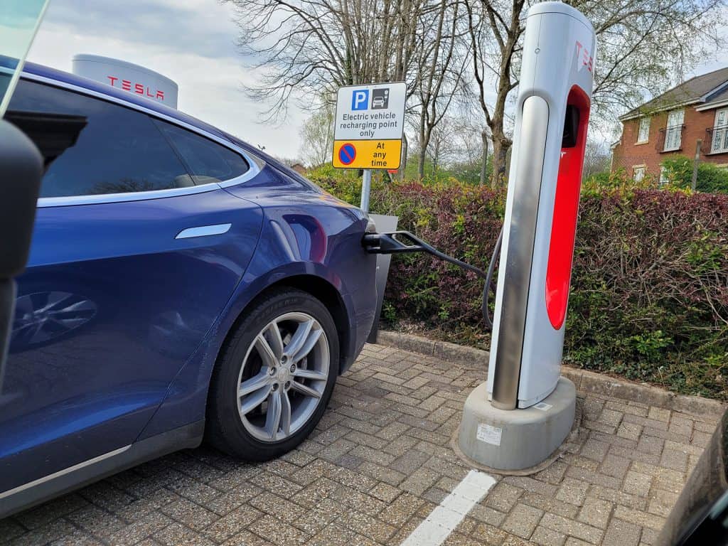 A Tesla plugged into a Tesla Supercharger EVSE station