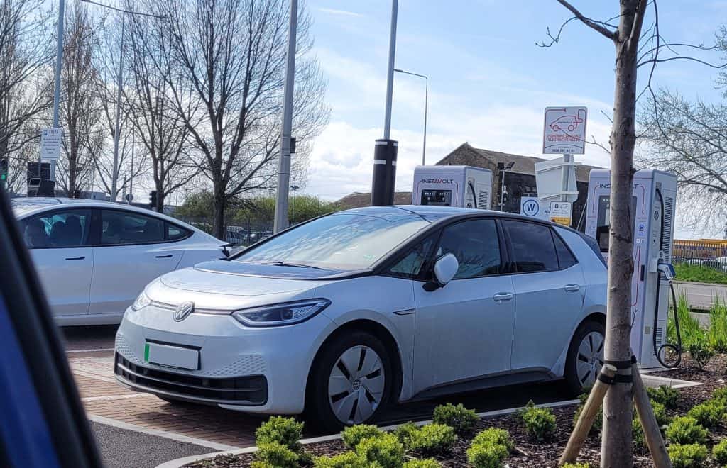 A VW ID.3 charging up at an Instavolt station with a Tesla Model 3 in the background