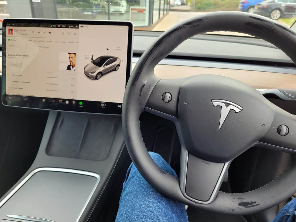 The touchscreen and steering wheel of a Tesla Model Y