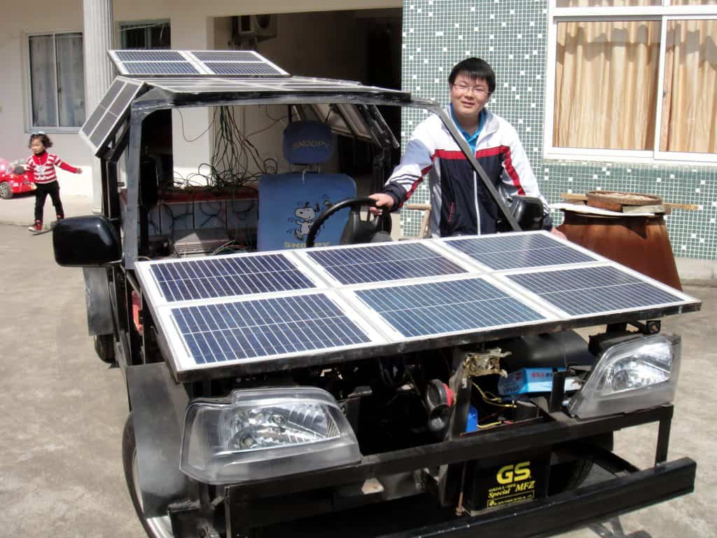 Chinese student Zhu Zhenlin aged 19 posing with his solar powered homemade EV